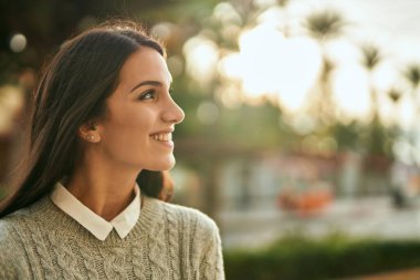 Genç İspanyol kadın gülümseyerek şehirde mutlu mesut dikiliyor..