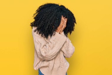Genç Afro-Amerikalı kız, günlük kıyafetler giyip ağlarken suratını ellerle kapatıyor. depresyon kavramı. 