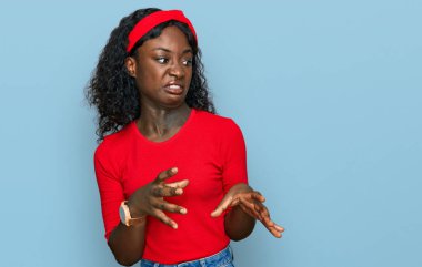 Güzel Afrikalı genç bir kadın, günlük giysiler giyiyor, tiksindirici ifadeler takınıyor, tiksindirici bakışlar atıyor, tiksindirici bakışlar atıyor.. 