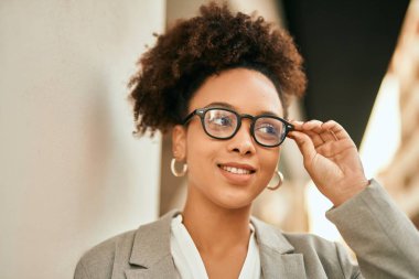 Genç Afrikalı Amerikalı iş kadını şehirde mutlu bir şekilde dikiliyor..