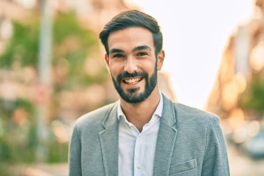 Genç İspanyol işadamı gülümseyerek şehirde mutlu mesut duruyor..