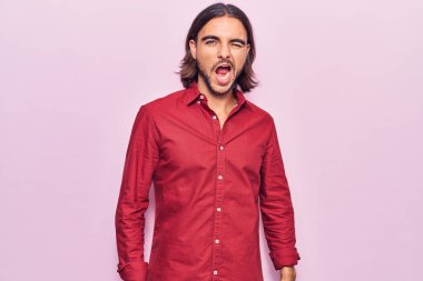 İş kıyafetleri içinde genç yakışıklı bir adam kameraya seksi bir ifadeyle bakıyor, neşeli ve mutlu bir yüz.. 