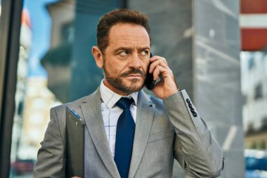 Şehirdeki akıllı telefondan konuşan orta yaşlı bir işadamı..