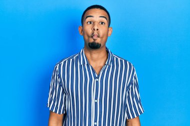 Genç Afro-Amerikan adam günlük kıyafetler giyip dudaklarıyla balık suratı yapıyor, çılgınca ve komik bir jest. Komik ifade. 