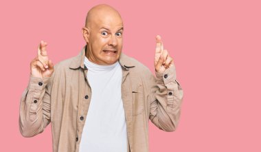 Orta yaşlı, kel, sıradan kıyafetler giyen, el kol hareketi yapan umut ve gözlerle gülümseyen bir adam. Şans ve batıl inançlar. 