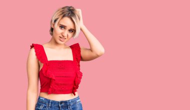 Gündelik giysiler giyen genç, güzel sarışın kadın soru sorup kafasını karıştırıyor. Şüpheyle kararsız, kafa kafaya düşünerek. Düşünceli kavram. 