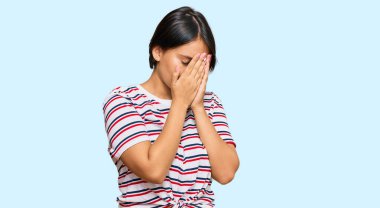 Kısa saçlı, sıradan kıyafetler giyen, suratını ellerle örten ve ağlayan güzel bir genç kadın. depresyon kavramı. 