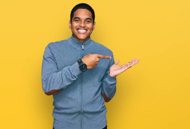 Genç, yakışıklı, sıradan bir kazak giyen İspanyol adam kameraya hayret ediyor ve gülümsüyor.. 