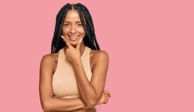 Güzel İspanyol kadın gündelik kıyafetler giyiyor kameraya kendinden emin bakıyor kollarını kavuşturmuş ve çenesini kaldırmış gülümsüyor. Olumlu düşünmek. 