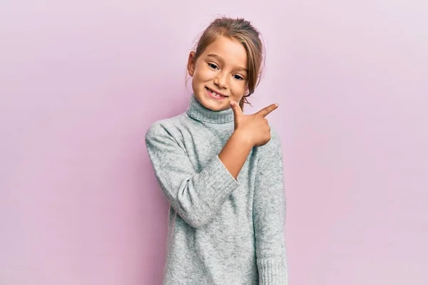 Kleines Schönes Mädchen Lässigem Rollkragenpullover Lächelt Fröhlich Und Zeigt Mit — Stockfoto