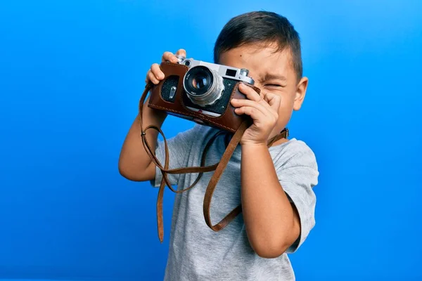 愛らしいラテン写真家幼児笑顔幸せな使用ヴィンテージカメラ上の隔離された青の背景 — ストック写真