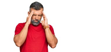 Stres yüzünden başı ağrıyan orta yaşlı, yakışıklı bir adam günlük kıyafetler giyiyor. migren ağrısı. 