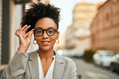 Genç Afrikalı Amerikalı iş kadını şehirde mutlu bir şekilde dikiliyor..