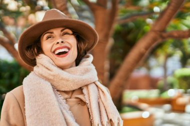 Şık giyinen genç İspanyol kadın şehirde dikiliyor..