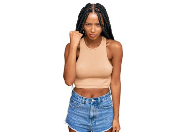 Güzel İspanyol kadın rahat kıyafetler giyiyor kızgın ve kızgın yumruğunu kaldırıyor ve öfkeyle bağırıyor. öfke ve agresif konsept. 