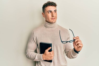 İspanyol genç adam kitap okuyor ve elinde kadehlerle gülümsüyor. Yan tarafa bakıyor ve düşünüyor.. 