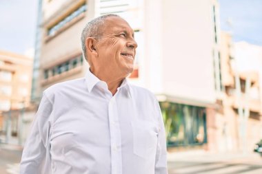 Son sınıf öğrencisi gülümseyerek şehirde mutlu mesut yürüyor..