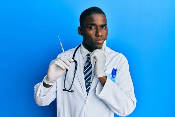 Joven Afroamericano Médico Hombre Sosteniendo Jeringa Cara Seria Pensando Pregunta — Foto de Stock
