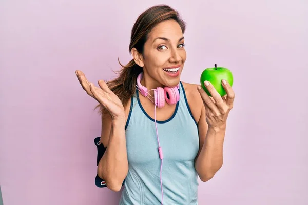 Mujer Latina Joven Usando Ropa Gimnasio Usando Auriculares Comiendo Manzana — Foto de Stock