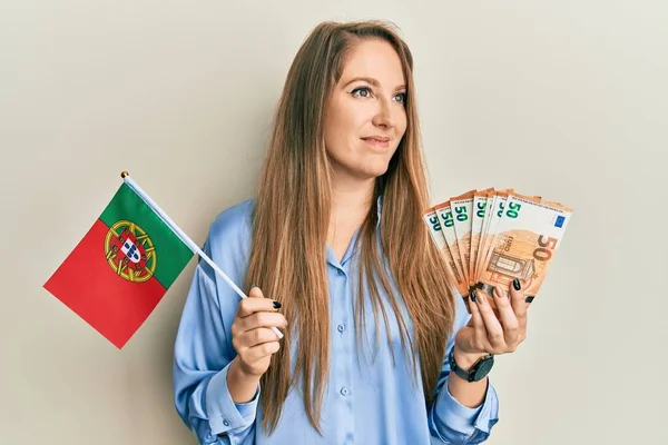 Joven Mujer Rubia Sosteniendo Bandera Portugal Billetes Euros Sonriendo Mirando —  Fotos de Stock