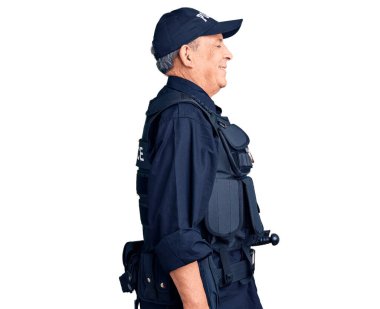 Kıdemli yakışıklı adam polis üniforması giyiyor. Taraf arıyor, rahat poz veriyor. Kendine güvenen bir gülümseme takınıyor.. 