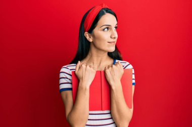 Genç İspanyol kadın elinde kitapla gülümseyip yan tarafa bakıyor ve düşünüyor.. 