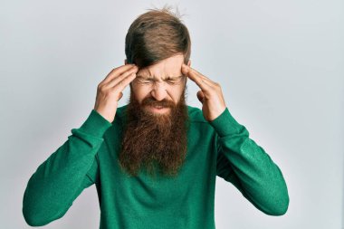 Kızıl saçlı, uzun sakallı, günlük kıyafetler giyen, başı ağrıyan bir adam. Stres yüzünden. migren ağrısı. 