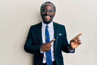 Yakışıklı, iş elbisesi giymiş, kravat takmış, gülümseyen ve kameraya bakan genç bir adam.. 