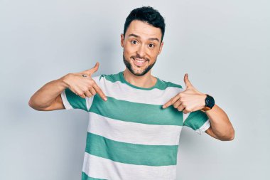 Günlük kıyafetler giyen, kendine güveni olan, kendini gururlu ve mutlu gösteren genç İspanyol bir adam.. 