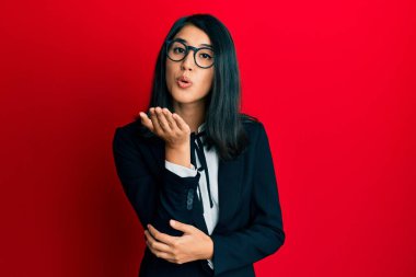 Güzel Asyalı genç bayan iş elbisesi giymiş kameraya bakıyor ve havada bir öpücük savuruyor sevimli ve seksi. aşk ifadesi. 