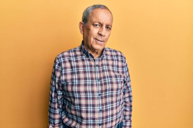 Gri saçlı, rahat tişörtlü, yakışıklı ve yakışıklı bir adamdı. Yüzünde ciddi bir ifade vardı. Basit ve doğal bir şekilde kameraya bakıyorsun.. 