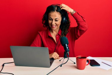 Radyo stüdyosunda çalışan orta yaşlı güzel bir kadın soru sorup kafasını karıştırıyor. Şüpheyle kararsız, kafa kafaya düşünerek. Düşünceli kavram. 