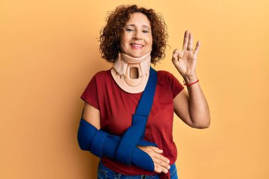 Güzel orta yaşlı olgun bir kadın boyun tasması takıyor ve kol askıda tamam işareti yapıyor parmaklarıyla gülümseyerek mükemmel bir işaret veriyor. 