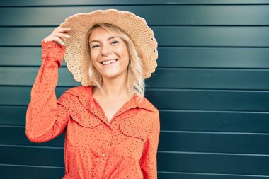 Genç, sarışın, gülümseyen, şehirde mutlu yürüyen bir kadın..