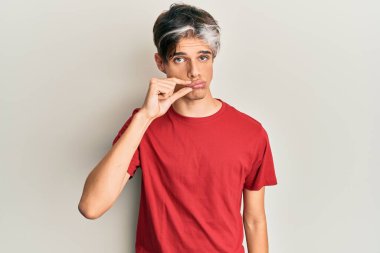 Gündelik kıyafetler giyen genç İspanyol adam ağzı ve dudakları parmaklarıyla kapanan fermuar gibi kapalı. gizli ve sessiz, tabu konuşması 