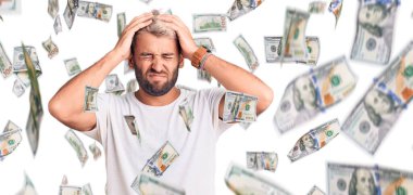 Genç, sarışın, sıradan tişörtler giyen, yorgun görünen ve depresyondan sıkılmış, kollarını kavuşturmuş genç bir adam..