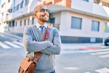 Genç Afrikalı Amerikalı iş adamı gülümseyerek şehirde mutlu bir şekilde yürüyor..