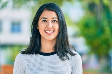 Genç İspanyol kadın gülümseyerek parkta mutlu bir şekilde yürüyor..