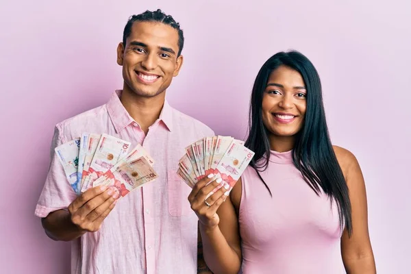 Jovem Casal Latino Segurando Pesos Colombianos Olhando Positivo Feliz Sorrindo — Fotografia de Stock