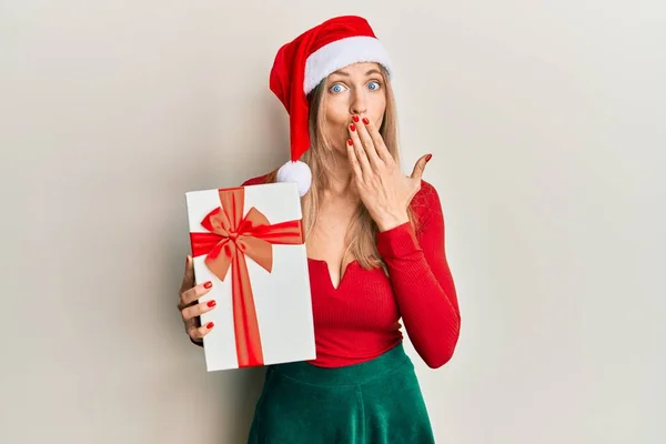 아름다운 코카서스 크리스마스 모자를 손으로 가리는 선물을 실수로 충격을 두려워하고 — 스톡 사진