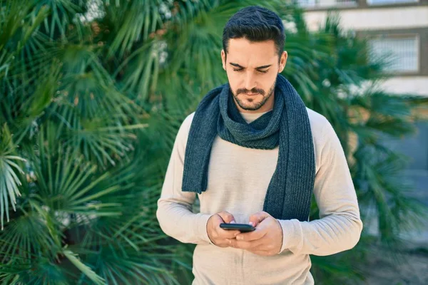 Joven Hombre Hispano Con Expresión Seria Usando Smartphone Parque — Foto de Stock