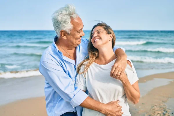 Pareja Hispana Mediana Edad Sonriendo Feliz Abrazándose Caminando Playa —  Fotos de Stock
