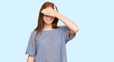 Gündelik giysiler ve gözlük takan, gülümseyen ve elleri yüzlerinde, şaşırtmak için gözlerini kapatan genç, okumuş bir kadın. kör kavram. 