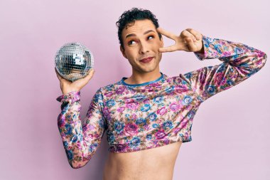 Parlak disko topunu tutan yakışıklı adam gülümsüyor ve yan tarafa bakıyor ve düşünüyor.. 