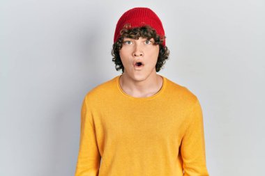 Yün şapka takan yakışıklı genç adam şaşırmış, korkmuş ve şok olmuş bir ifade, korku ve heyecanlı bir yüz.. 
