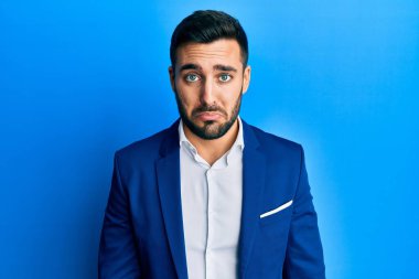 Genç İspanyol iş adamı depresif ve endişeli, sinirli ve korkmuş bir şekilde iş ceketi giyiyor. hüzünlü ifade. 