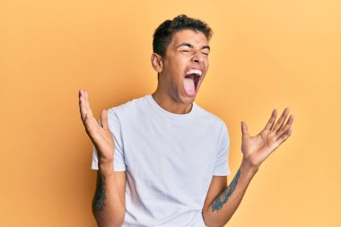 Genç, yakışıklı, Afro-Amerikalı bir adam. Günlük beyaz tişört giyiyor. Deli gibi bağırıyor, bağırıyor, agresif bir ifade ve kollar havada. hüsran kavramı. 
