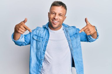 Yakışıklı, sıradan kot ceket giyen, kendine güveni olan, kendini gururlu ve mutlu gösteren kaslı bir adam.. 