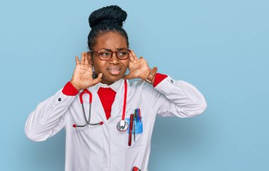 Doktor üniforması ve steteskop giyen genç Afro-Amerikan kadın iki elini de kulak hareketi yaparken duymaya çalışıyor, dedikoduya meraklı. İşitme sorunu, sağır 