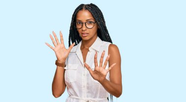 Güzel İspanyol kadın günlük kıyafetler ve gözlük takıyor korku ifadesinden korkuyor ve dehşete düşüyor. El kol hareketi yapmayı kes, şok içinde bağırmayı kes. panik konsepti. 